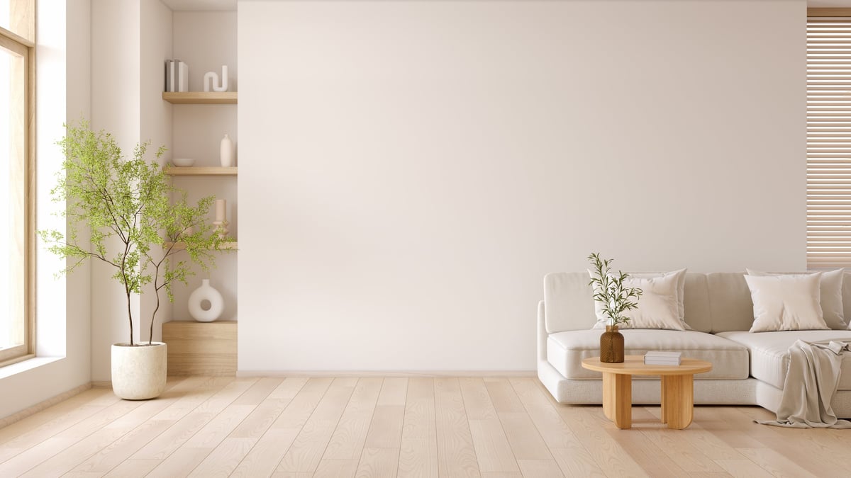 Salón luminoso y minimalista con sofá moderno, mesa de centro y paredes blancas
