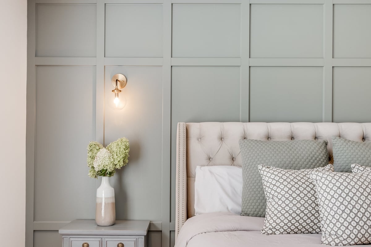 Dormitorio de diseño moderno con tonos verdes y cama vestida